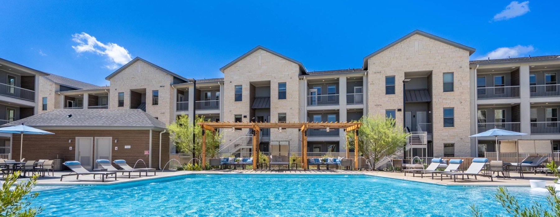 resort style pool with seating and a building behind it